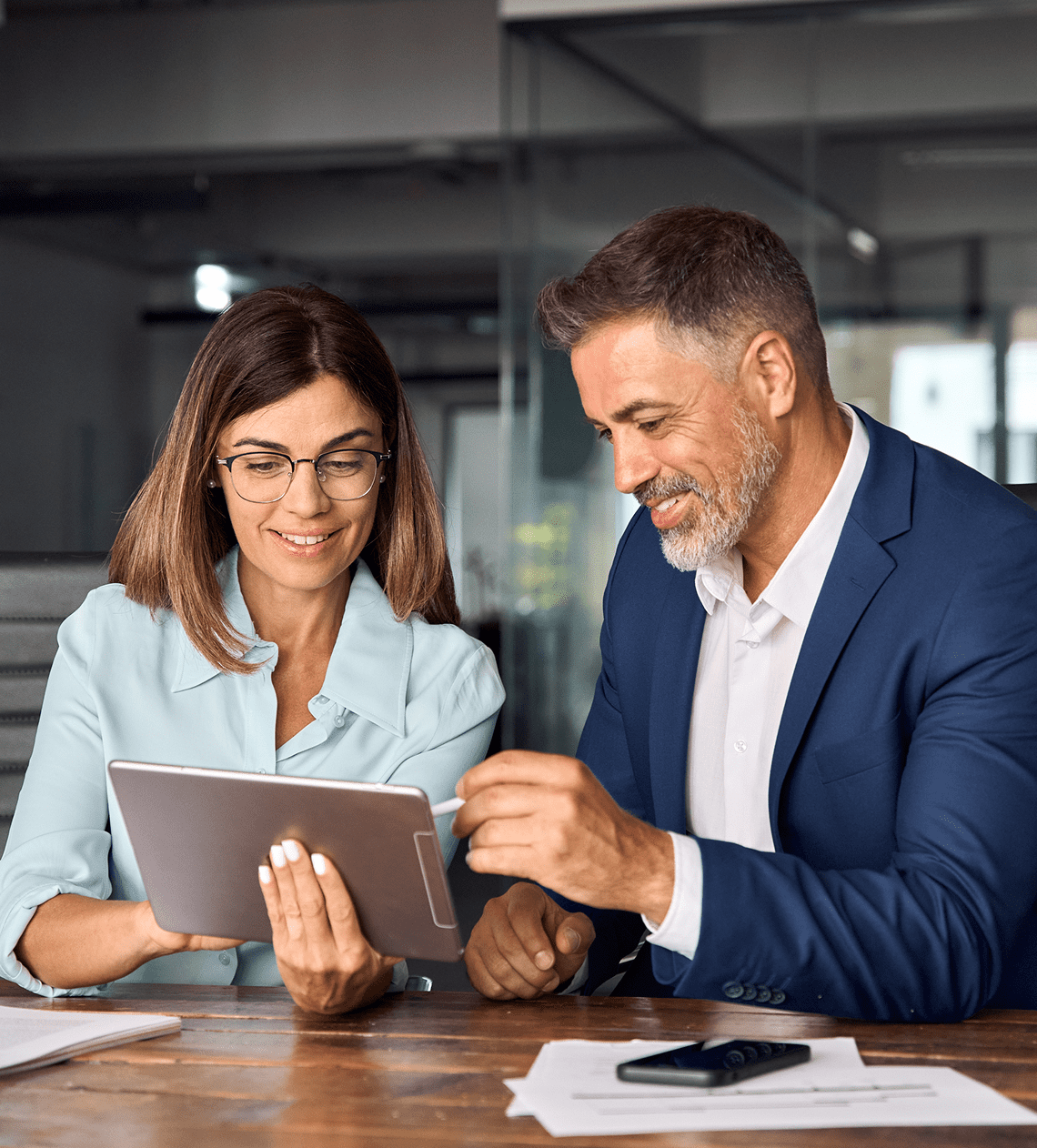 Two colleagues discussing work on a tablet