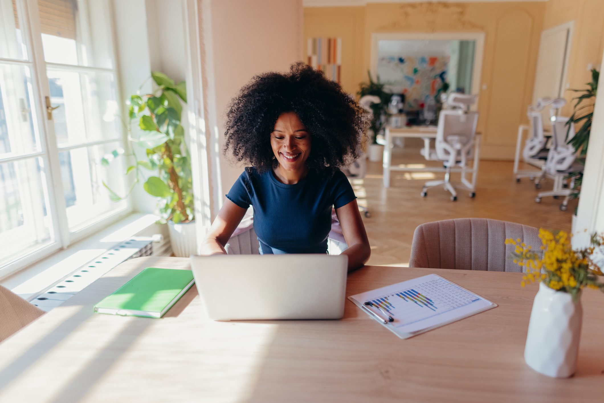 Smiling woman at desk with laptop